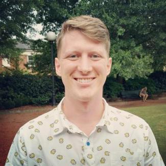 Photograph of Kyle Vanderniet outside in front of greenery